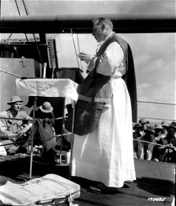 SC 170425 - Chaplain Hawley, Catholic priest, aboard a transport, celebrates the Holy Sacrifice of the Mass on Sunday, June 23, 1942.. photo