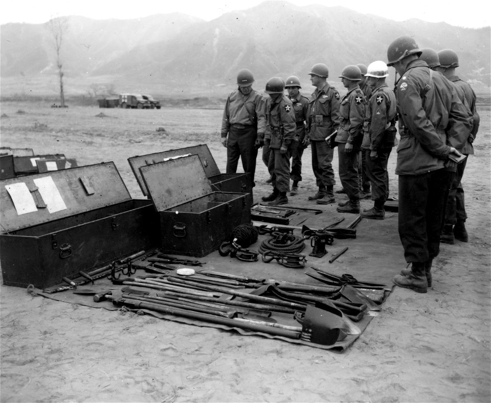 SC 364026 - Lt. Gen. Edward M. Almond, left, CG X Corps, examines pioneer tools during his tour of inspection at the 9th Regt., 2nd Inf. Div. area, Korea.