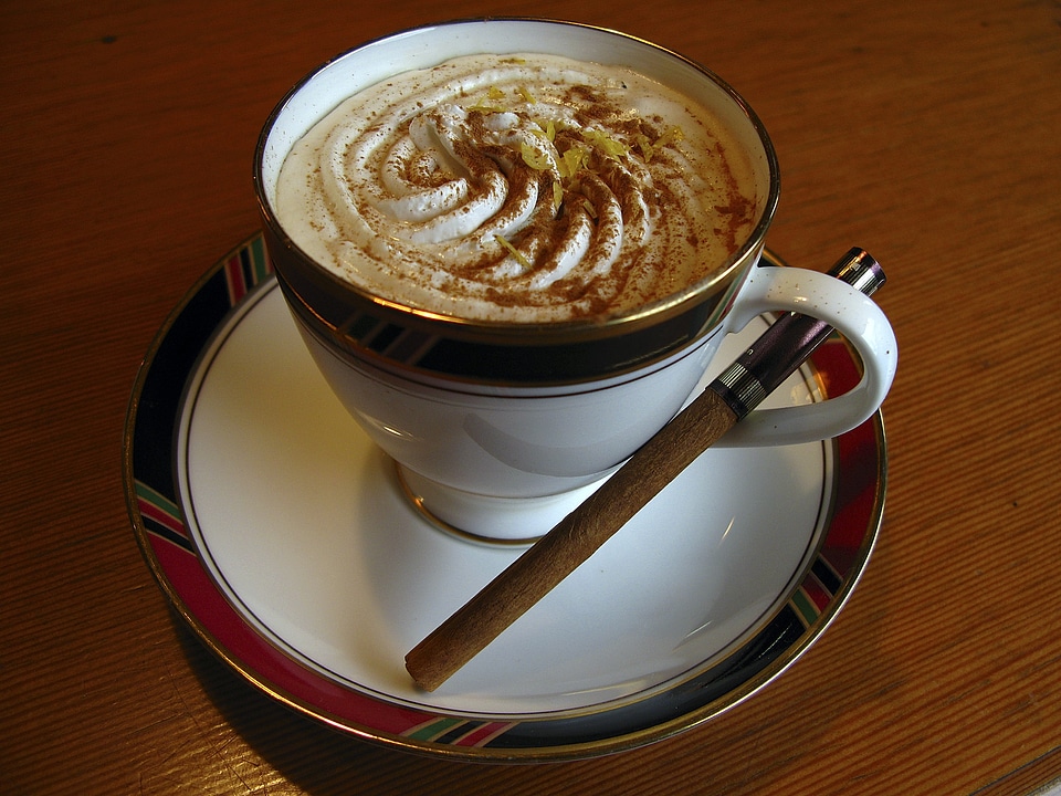 A cup of coffee with a white cup on wooden background