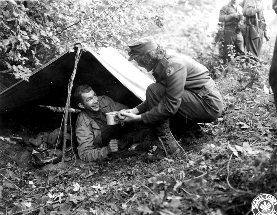 SC 329727 - Pvt. Garnett N. Early, of Harrisonburg, Va., receives an early morning cup of coffee from Red Cross worker Mary Jane Cook, of Jackson Heights, N.Y. Nancy, France. 19 September, 1944.