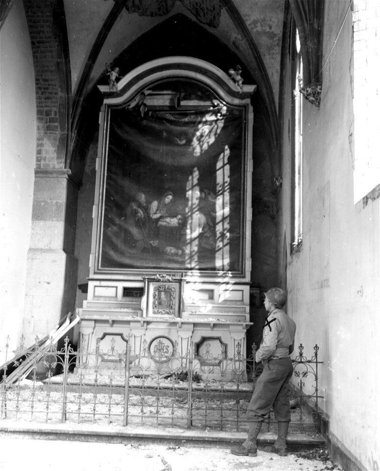 SC 374658 - T/3 Walter Erhard, of Mt. Vernon, N.Y., a member of the 95th Division, 9th U.S. Army, looks at painting of the Adoration of the Magi, in the ruins of  Mönchen church, in the town of Mönchengladbach, Germany.