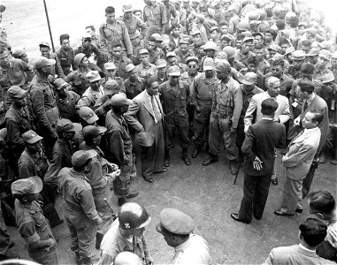 SC 348890 - The Philippine representative, Maximo Bueno, chairman of the UN Committee on Korean affairs (with hand in pocket), talks to some of the Philippine combat troops arriving in Korea by troop transport at Pusan, Korea. 19 September, 1950. photo