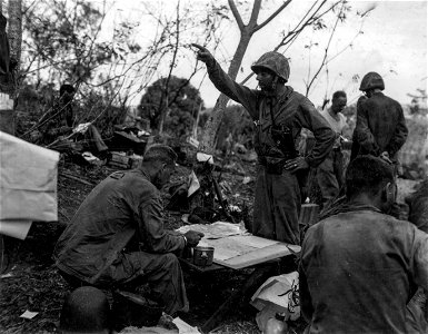 Col. Franklin A. Hart (sitting) commander of the 24th Marines of Eufala, Alabama, talks over the frontline situation with one of his front line officers Major Fricke, Richmond, Virginia.
