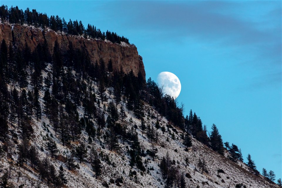The moon rises over a snow-dusted Mt. Everts