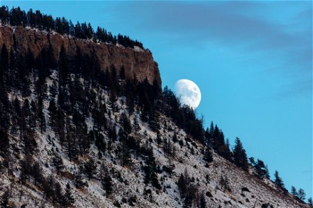The moon rises over a snow-dusted Mt. Everts photo