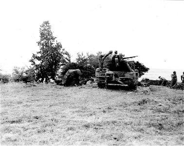 SC 364505 - AA battery sets on shore near [illegible], Luzon, P.I., as destroyer off shore fires on Jap targets in the rear. 12 January, 1945.