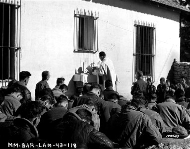 SC 170043 - Chaplain Walter J. Poynton, Inglewood, N.J, holds church services in the courtyard of a French school building for a bomber group in North Africa. 12 February, 1943.
