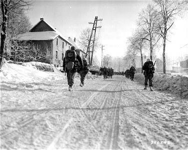 SC 270592 - Members of the 9th Infantry Regiment, 2nd Division, march into Butgenbach, Belgium. 25 January, 1945.