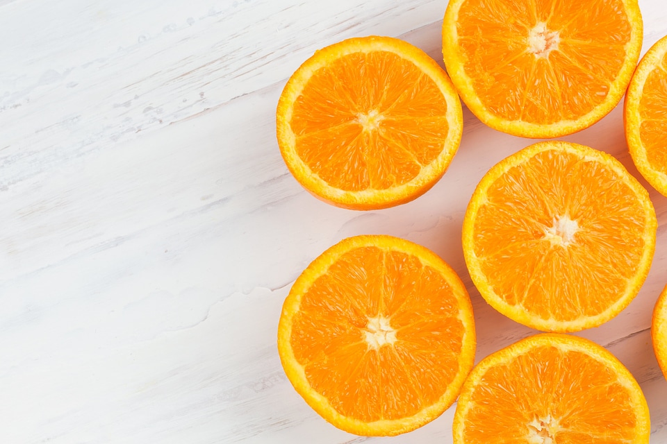 Sliced oranges placed on a white wooden table