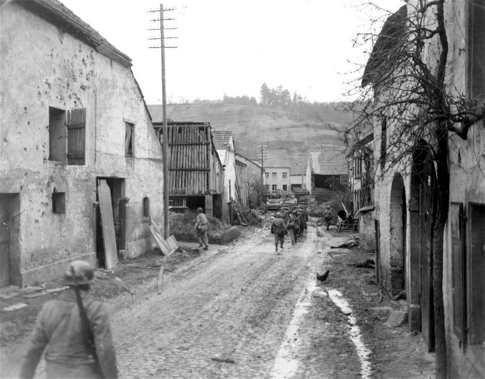 SC 334977 - German prisoners taken by 10th Armored Division of 3rd U.S. Army, in Irsch, are marched towards tank block at end of street. 26 February, 1945.