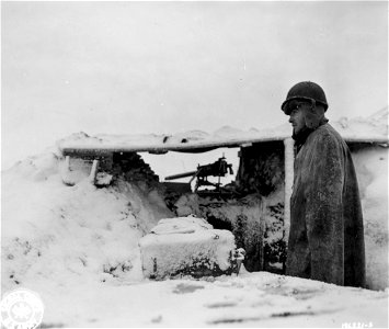 SC 196221-S - Sgt. Sam S. McNealy, Morgantown, N.C., stands watch by his machine gun during the first snowfall of the year in this sector of the western front.