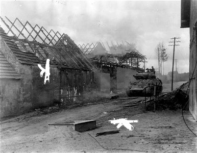 SC 336924 - Third U.S. Army tank moves past a burning building in Vorback, Germany. 19 April, 1945.