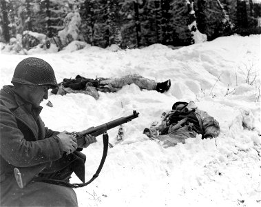 SC 198859 - Pfc. Frank Vukasin, Great Falls, Mont., stops to load clip in rifle while advancing in snow-covered front-line sector at Houffalize, Belgium. photo