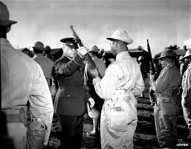 SC 151574 - During an inspection tour of colored troops of the Services of Supply somewhere in England, Brigadier Gen. Benjamin O. Davis examines a rifle of one of the men. 2 October, 1942. photo