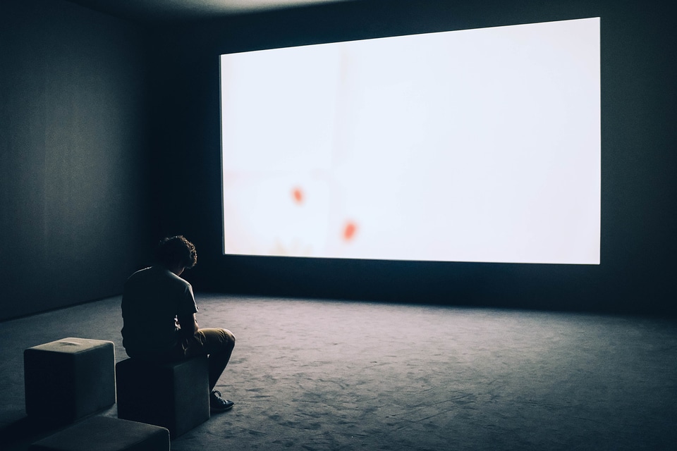 Silhouette of man's head in front of screen light at night