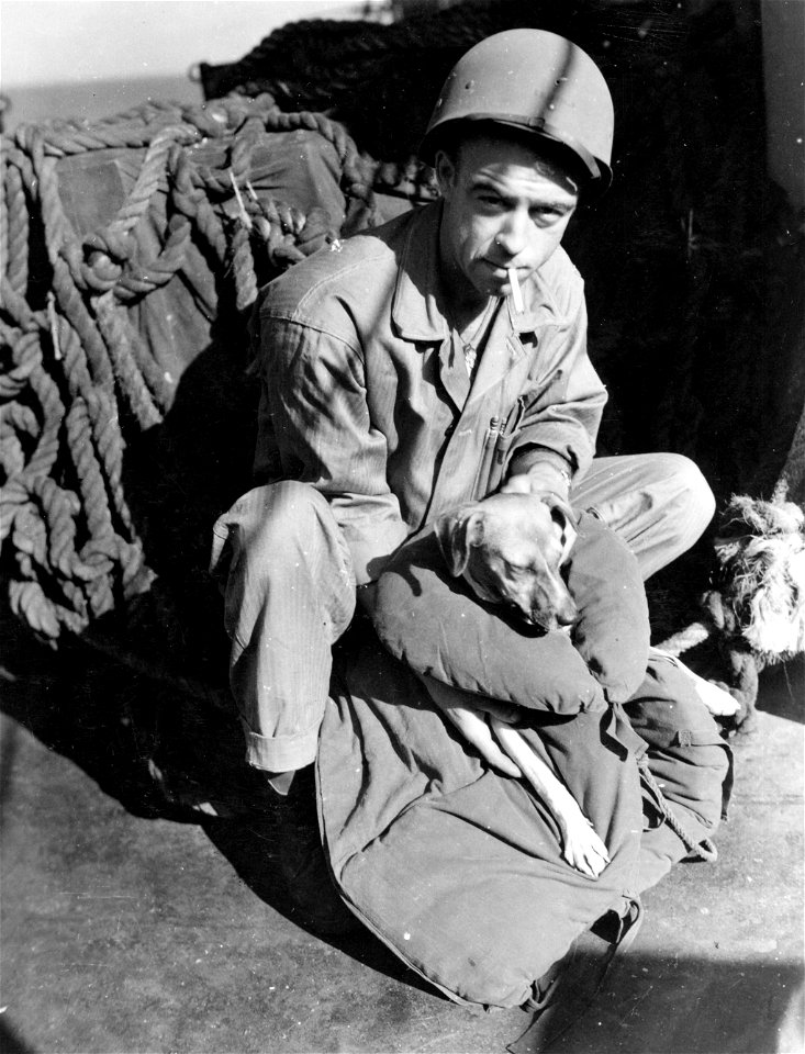 A Marine aboard ship enroute to Okinawa with the Second Division is shown placing his lifejacket on his "pal".