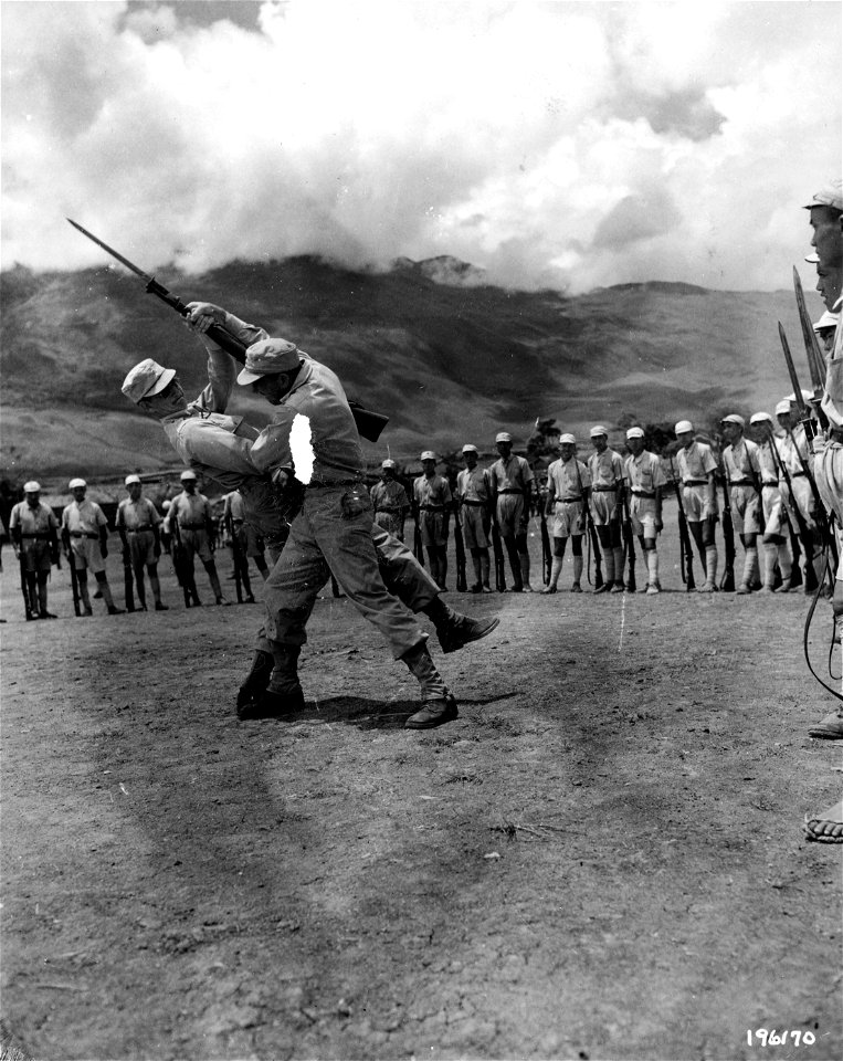 SC 196170 - For the benefit of Chinese soldiers in training, Sgt. P.O. Gibson, San Angelo, Texas, and 1st Lt. J.A. Itaples, Fargo, N.D., demonstrate methods of disarming an enemy with a bayonet. China. 1 September, 1944.