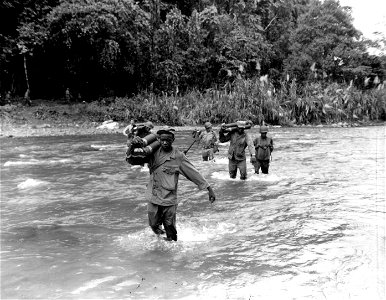 SC 196150 - Members of the 2nd Bn., 25th Combat Team, 93rd Div., wade across the Laruma River carrying mortar shells to the other side. photo