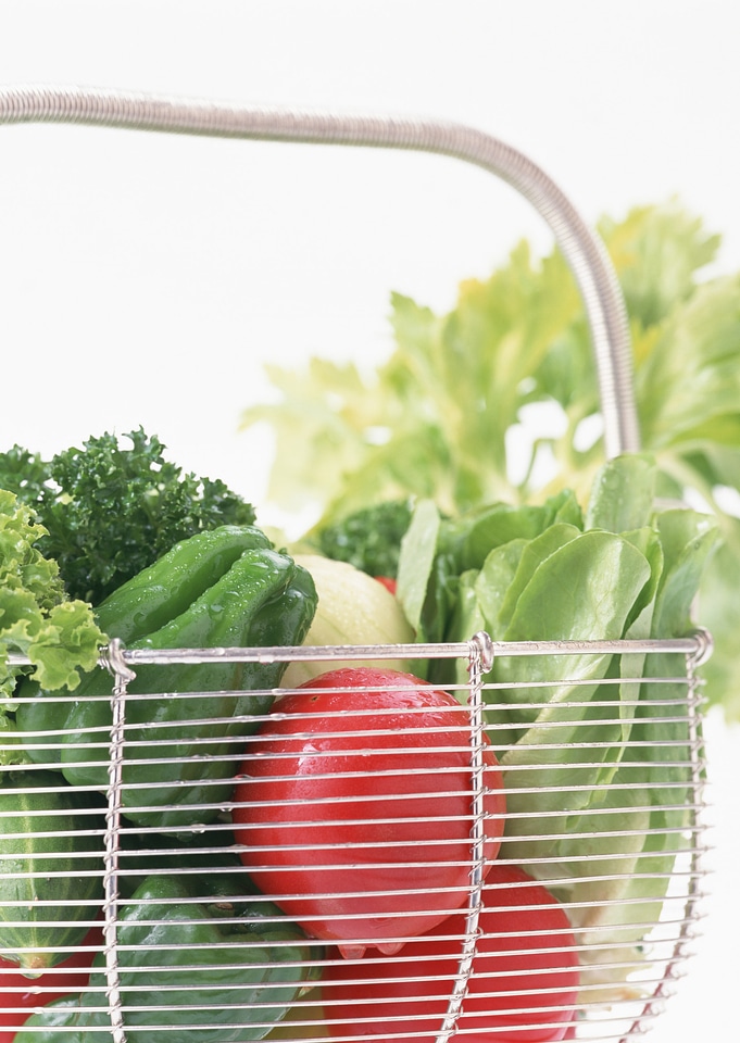 Photo of a wire shopping basket full of fresh fruit and vegetable