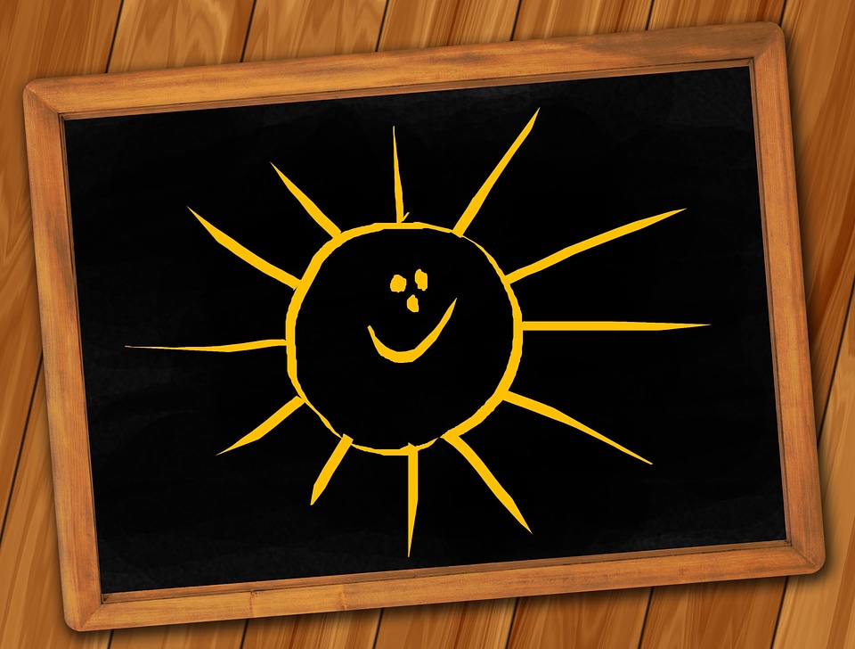 Black chalkboard. Drawn smile sun