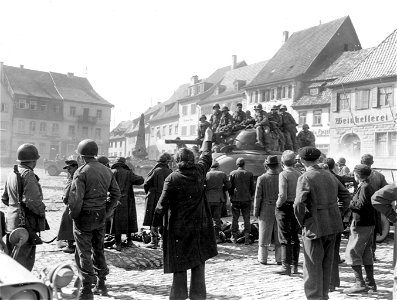 SC 335302 - Civilians watch tanks and infantrymen pass through the town of Konigshofen.