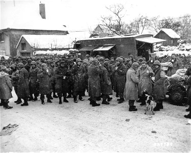 SC 329789 - Men moving up to the front, in the snow, are getting hot coffee and doughnuts from an American Red Cross Clubmobile near the front. photo