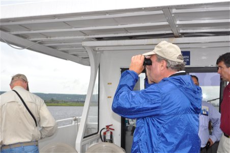Deputy Regional Director scopes out the island with binoculars. USFWS Photo. photo