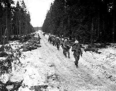SC 270826 - Infantrymen of the 39th Inf. Regt., 9th Inf. Div., move up road which yesterday was a battlefield in the Wahlerscheid area, of Germany. 2 February, 1945.