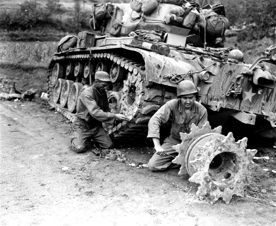 SC 348862 - Cpl. Earl W. Olson, Eau Claire, Wisc., left, and Cpl. George Holman, McAlester, Okla., right, members of a tank bn., 2nd Inf. Div., repair their tank, which was knocked out by enemy 57mm anti-tank gun 16 of Sept. 50 in the Mogong-Ni area.