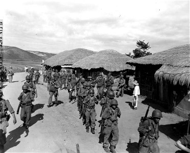 SC 348690 - Men of the 32nd Inf. Regt., 7th Div., advance through a Korean village 5 miles SE of Inchon, Korea. 18 September, 1950. photo