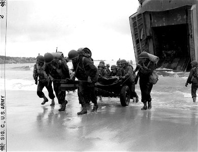 SC 335424 - When all else fails the men of the Cannon Co., 159th Infantry resort to manpower to get their guns out of the surf and into action. photo