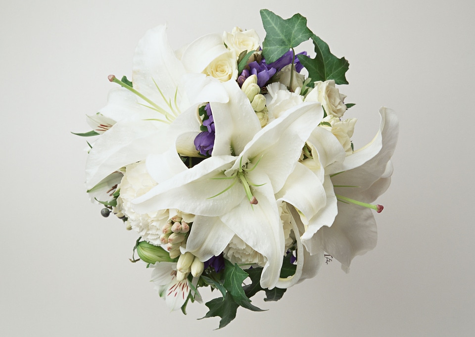 A big flower bouquet filled with cala lillies and other plants.