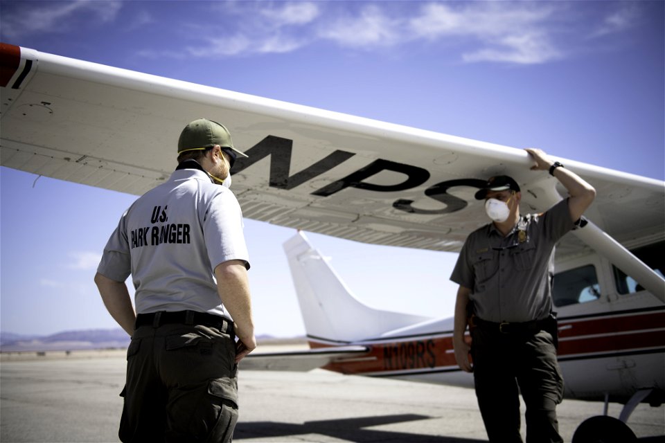 Park rangers next to NPS patrol plane