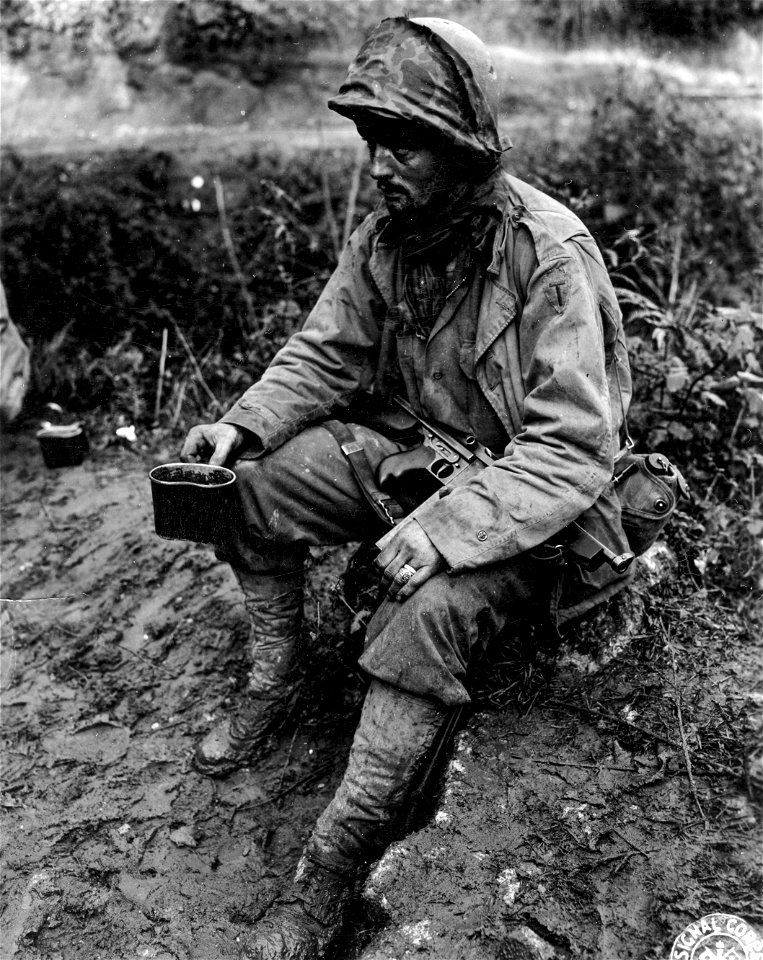 SC 364645 - Pvt. Ernest Wilson, Baltimore, Md., Co. L., 142nd Inf., Regt., sips hot coffee after completing round trip up mountain side with pack mule train.