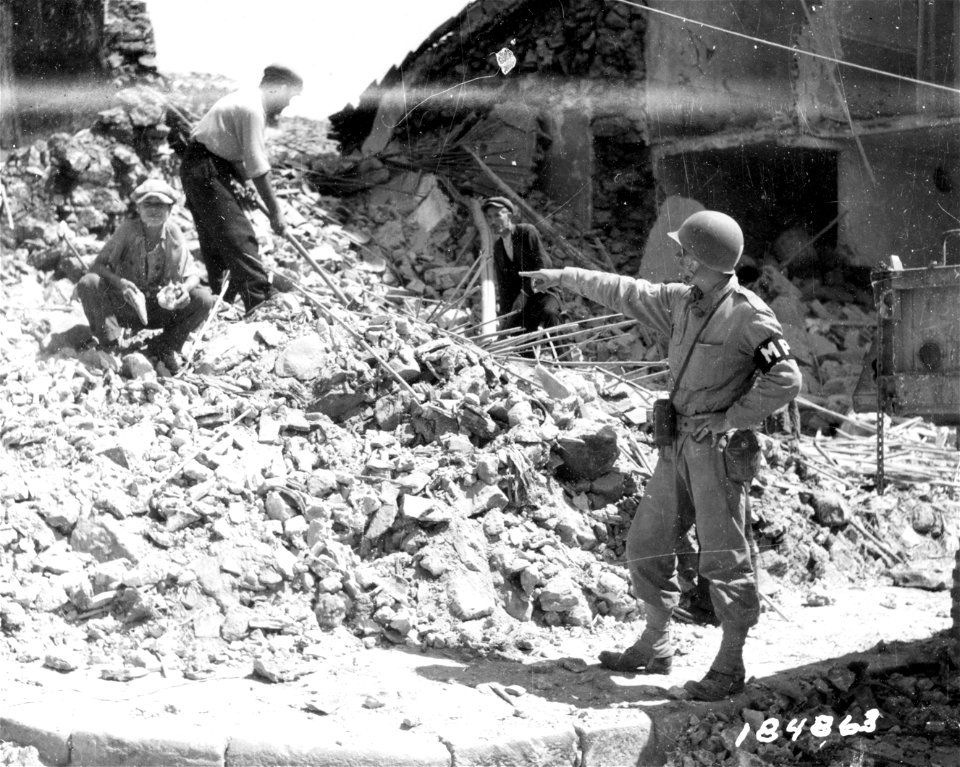 SC 184683 - Lt. Charles M. Conover, Seattle, Wash., directs removal of wreckage and bodies from wreckage near Barrafranca, Sicily. 19 July, 1943.
