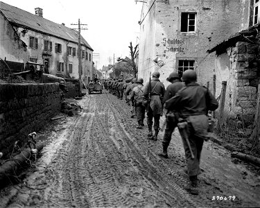 SC 270679 - Men of the 2nd Bn., 10th Regt., 5th Inf. Div., move along a street in Schankwieler, Germany, on their way to the frontlines. photo