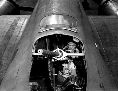 SC 180003 - T/Sgt. Arthur L. Smith, Norwich, Kansas, radio gunner of "Our Gang", a Flying Fortress operating from England, takes a final look over one of the ship's guns before she takes off on another mission over enemy territory. 24 June, 1943.