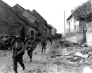 SC 270625 - Troops of the 3rd Bn., 7th Inf. Regt., 3rd Div., move through a muddy street in Montjustin-et-Velotte, France. 14 September, 1944. photo