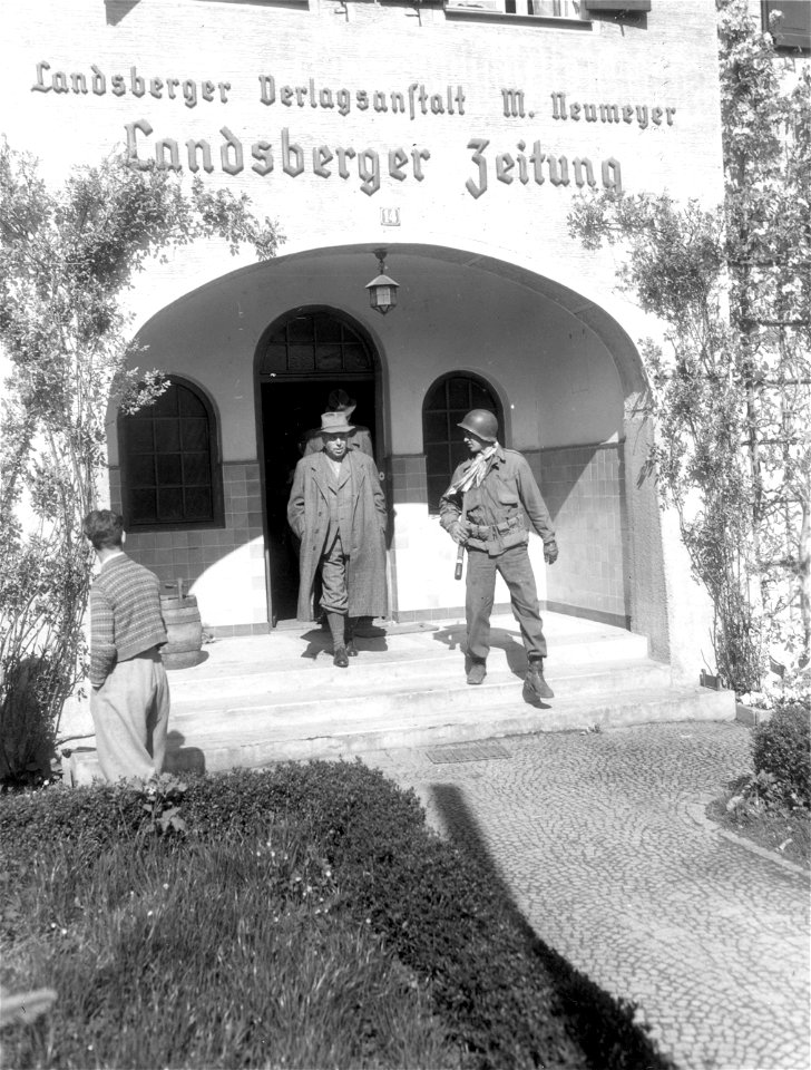 SC 335338 - Men of the 103rd Infantry Division round up all the male civilians in Landsberg, Germany, to go to the Stalag #4 concentration camp to bury political prisoners starved and burned to death by SS troops.