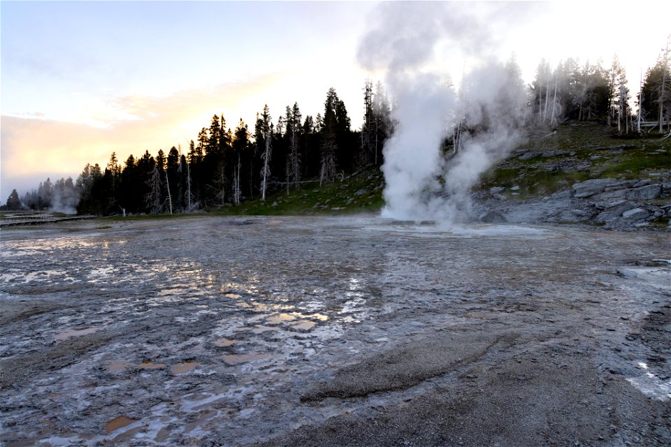 Sunrise over erupting Turban Geyser and Grand Geyser pool