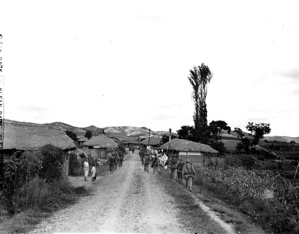 SC 348691 - South Korean villagers cheer the men of the 32nd Regt., 7th Inf. Div. as they advance to the front 15 miles southeast of Inchon, Korea. 18 September, 1950. photo