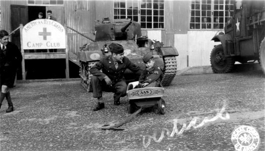 SC 329810 - At a U.S. Army Ordnance Depot, England, Allen [Censored], British war orphan adopted by U.S. Army ordnancemen at this depot, prepares to take off in his GI wagon built for him by his "uncles". photo