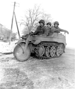 SC 199056-S - U.S. Army combat engineers of 102nd Division, 9th U.S. Army, ride in captured German vehicle in Baesweiler, Germany.
