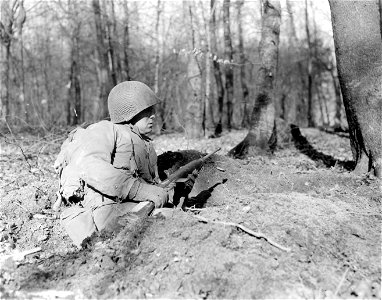 SC 270608 - Pfc. William O. Clothier, Rockhall, Md., shown in foxhole in woods near near Rockenfell, Germany.