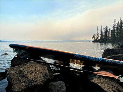 A paddleboard rests on a rock as smoke from the Cedar Creek Fire fills the sky in the background. Willamette National Forest, August 6, 2022 photo