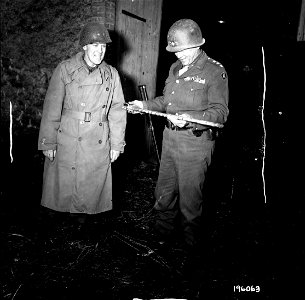SC 196063 - Maj. Gen. Paul J. Baade, commanding general of the 35th Division, shows his souvenir cane to Lt. Gen. George S. Patton, commanding general of the 3rd Army. photo