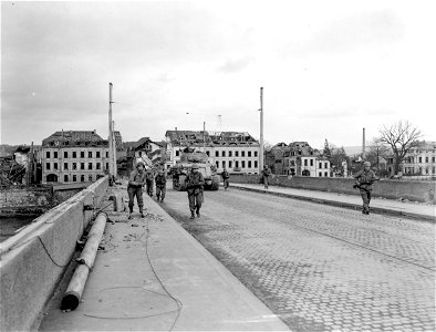 SC 270838 - Men and tanks of the 10th Armored Div. cautiously advance across a bridge spanning the Moselle River at Trier, Germany, which they captured intact in the 3rd Army's push towards the Rhine. photo