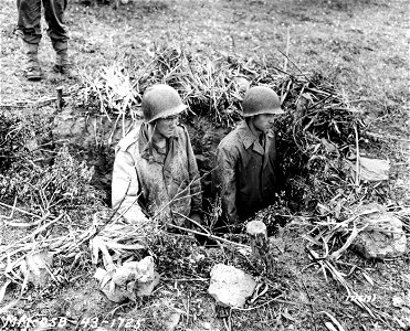 SC 171619 - Pfc. Fred V. Key, Towncreek, Ala., and Glenn E. Cox, Tampa, Fla., in a German entrenchment overlooking the valley which until this morning was not safe for American troops. 7 May, 1943.