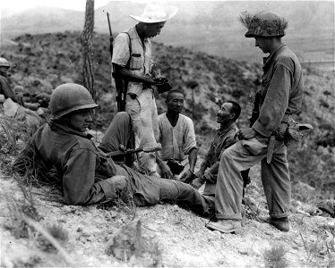 SC 348779 - Two North Koreans captured by men of  "F" Co., 19th Inf. Regt., 24th Inf. Div. south of Chinju, Korea, being searched and interrogated by S. Korean G-2 officer. 29 July, 1950.