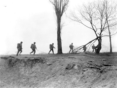 SC 270636 - Rhine Crossing: Seventh Army mortar squad runs for river bank through heavy protective smoke screen, to assault boats which will take them across the Rhine. photo